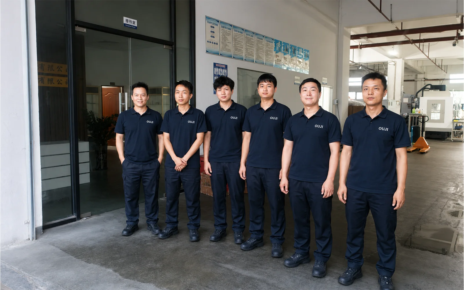 OUJI team members standing together in a manufacturing facility