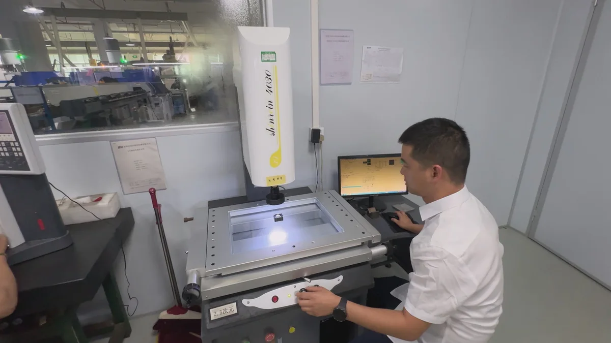 An OUJI technician using a vision measurement system to inspect a small component