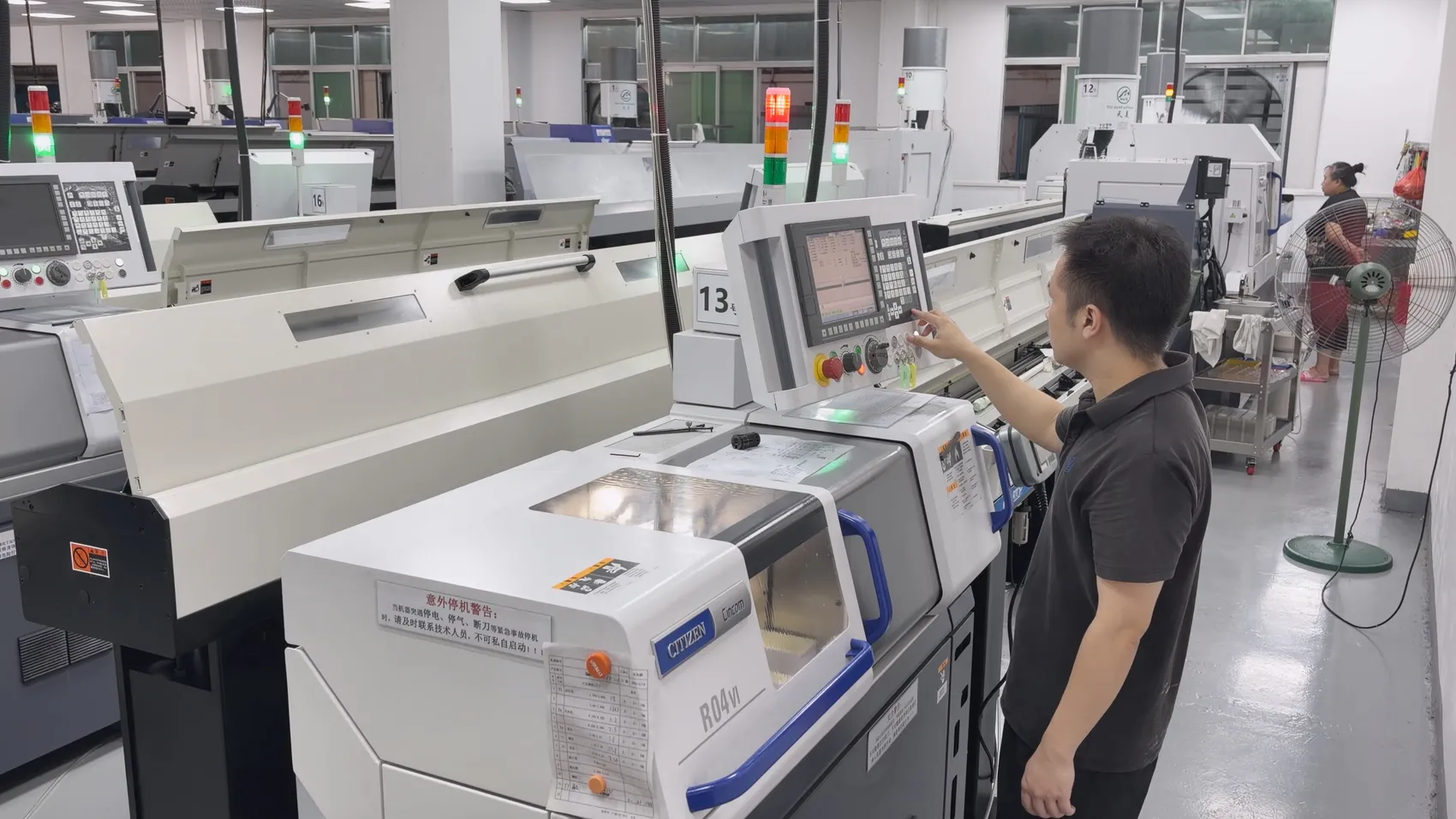 Machinist operating a Citizen Cincom R04VI Swiss-type CNC lathe on the production floor at OUJI