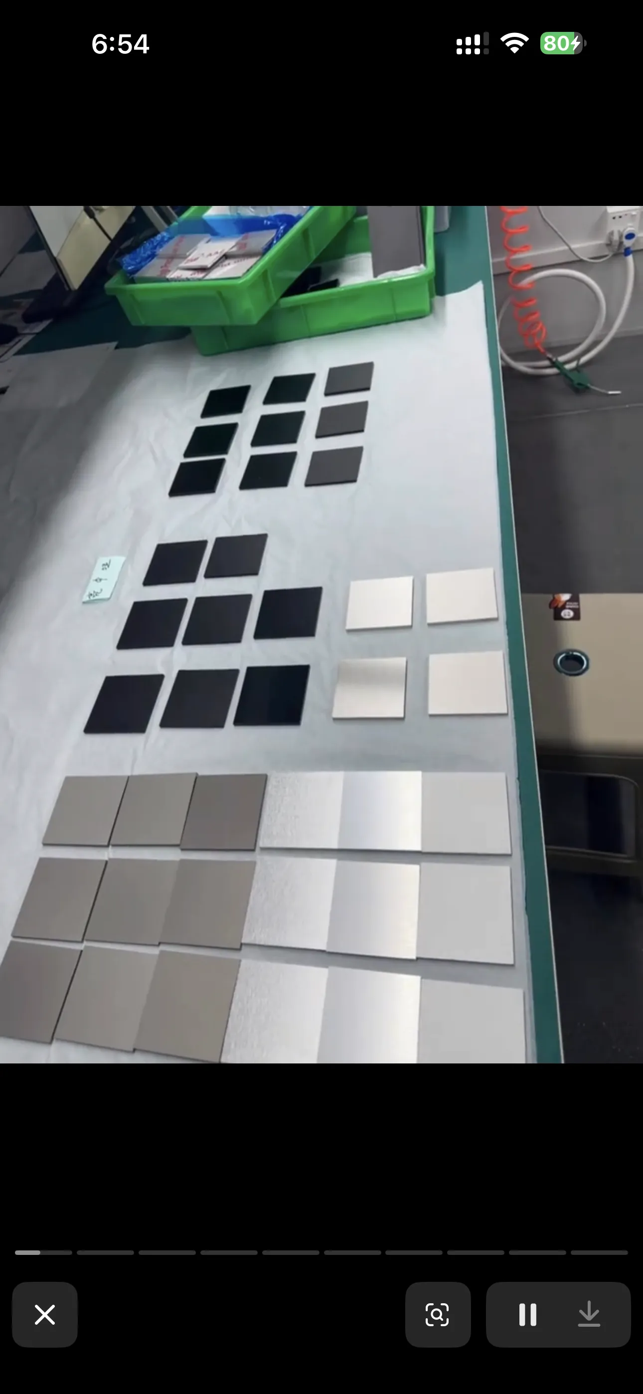 Physical anodize color sample board showing black, white, and metallic finish swatches used for color matching