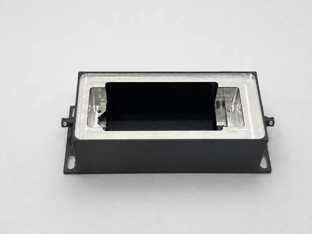 Black anodized aluminum prototype with selectively machined bare aluminum surfaces around the opening