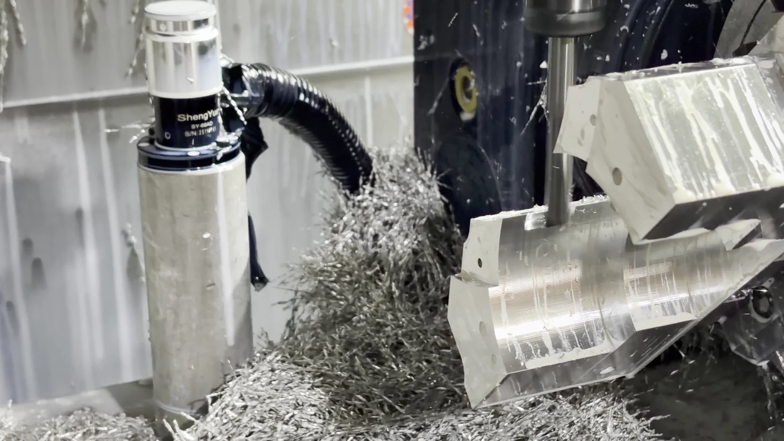 Multi-face aluminum component being cut at an indexed angle in a five-axis machining center