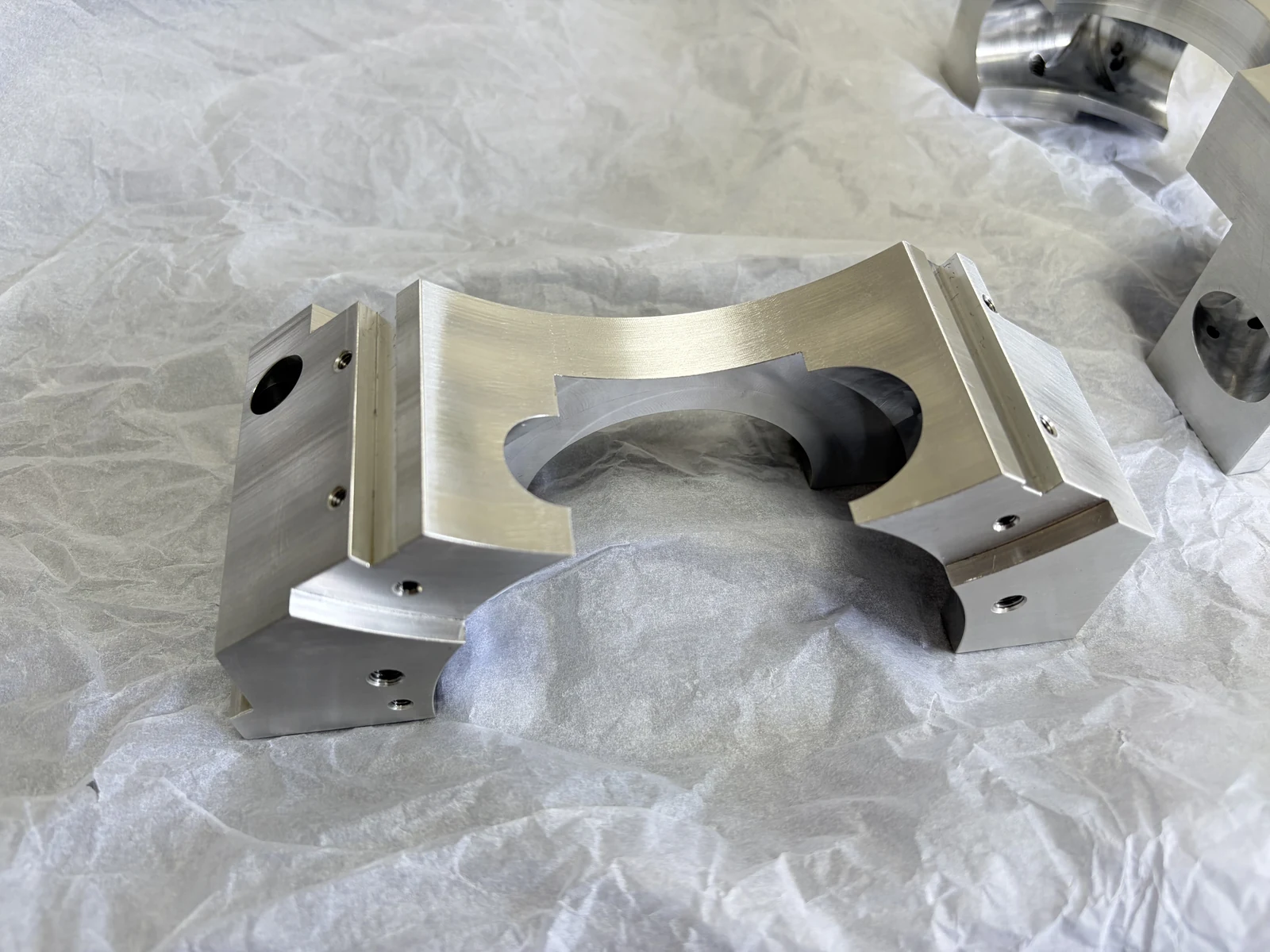Bare aluminum component after multi-face machining and removal of the temporary dovetail clamping feature