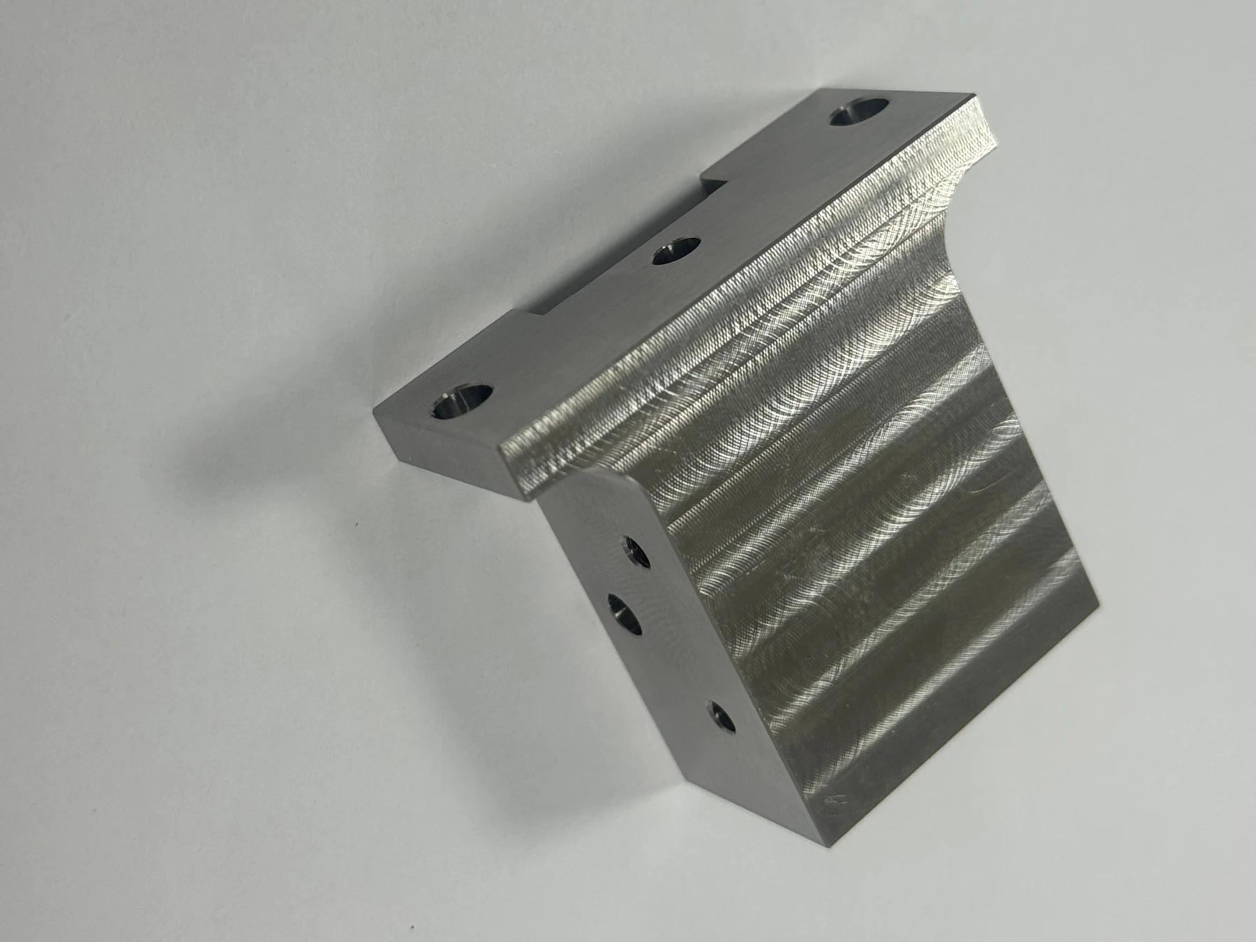 Finished 304 stainless steel component with bores and machined features on multiple faces