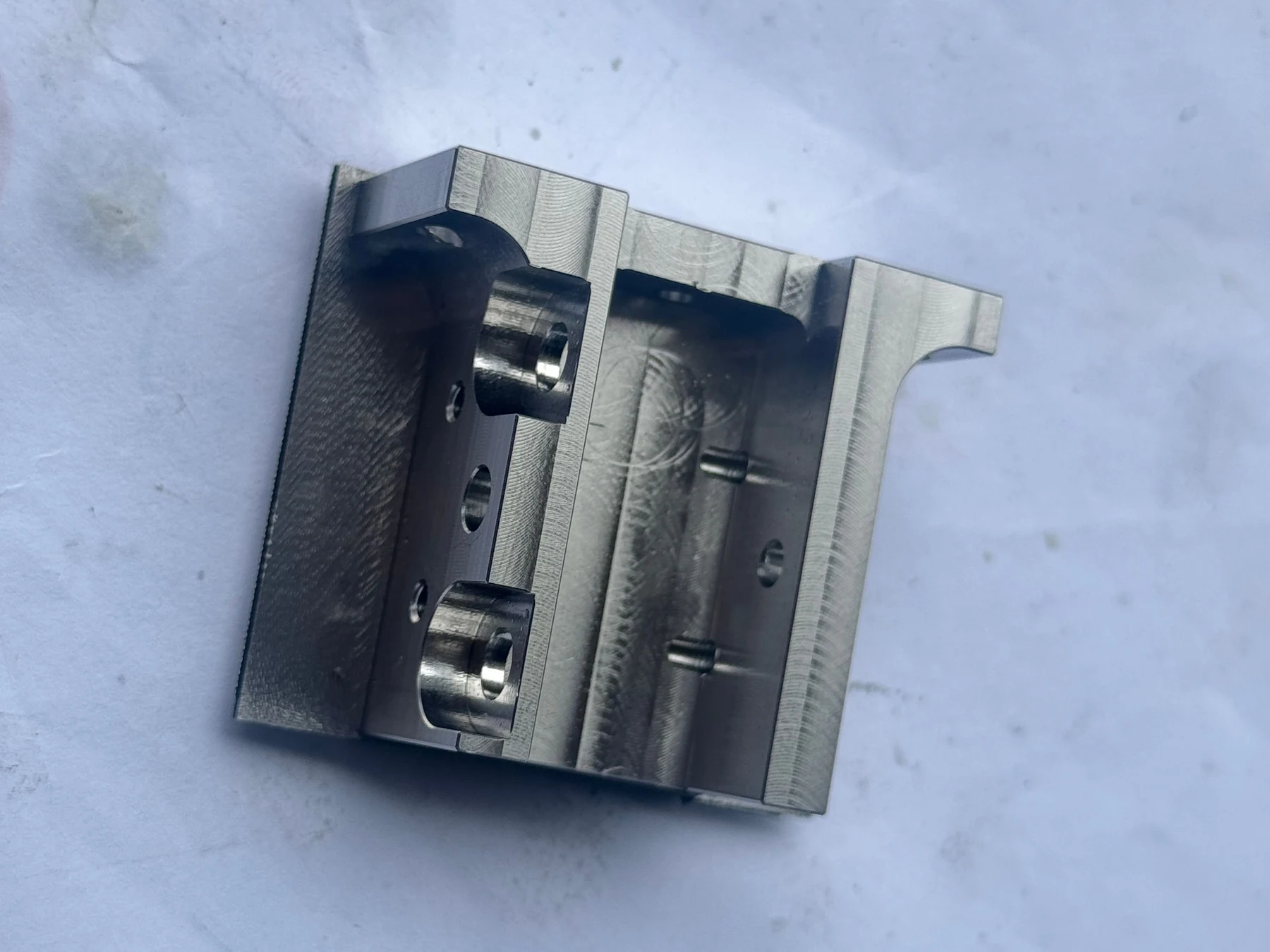 Finished 304 stainless steel component with bores and machined features on multiple faces