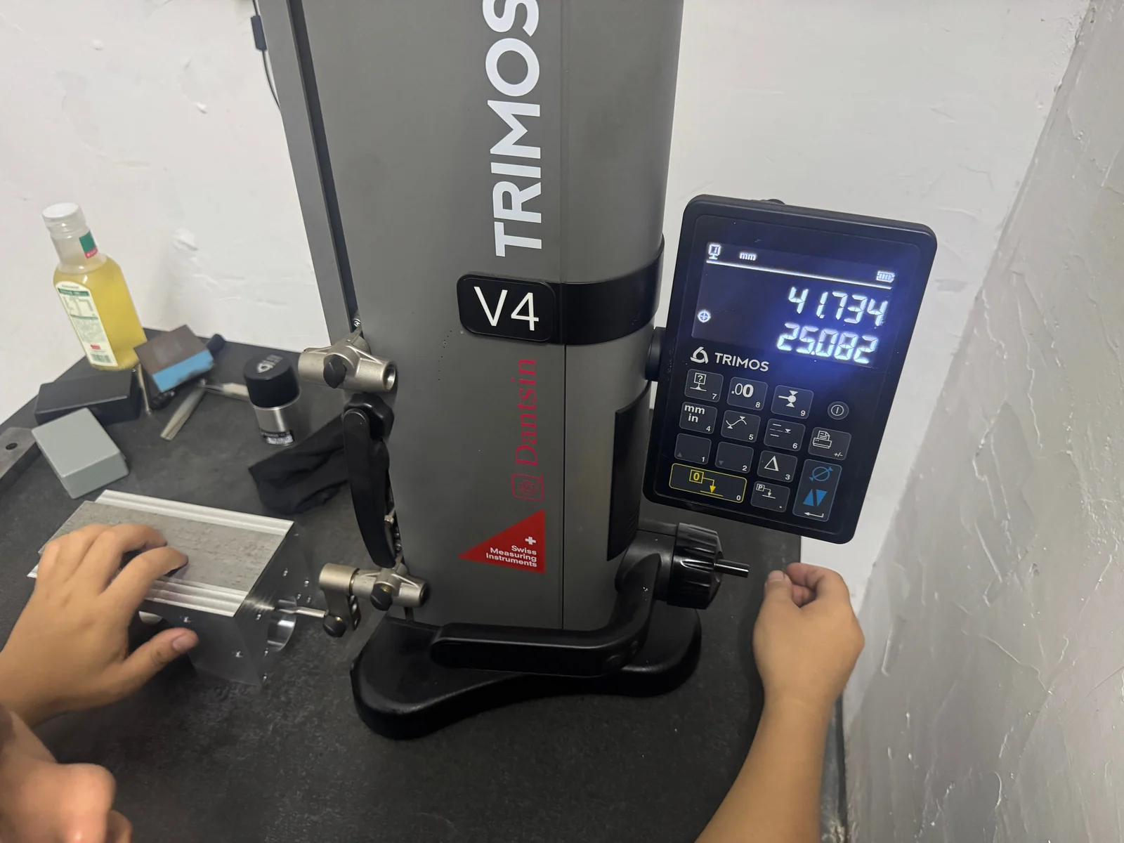 Height-gauge inspection of an intermediate stainless steel workpiece on a surface plate