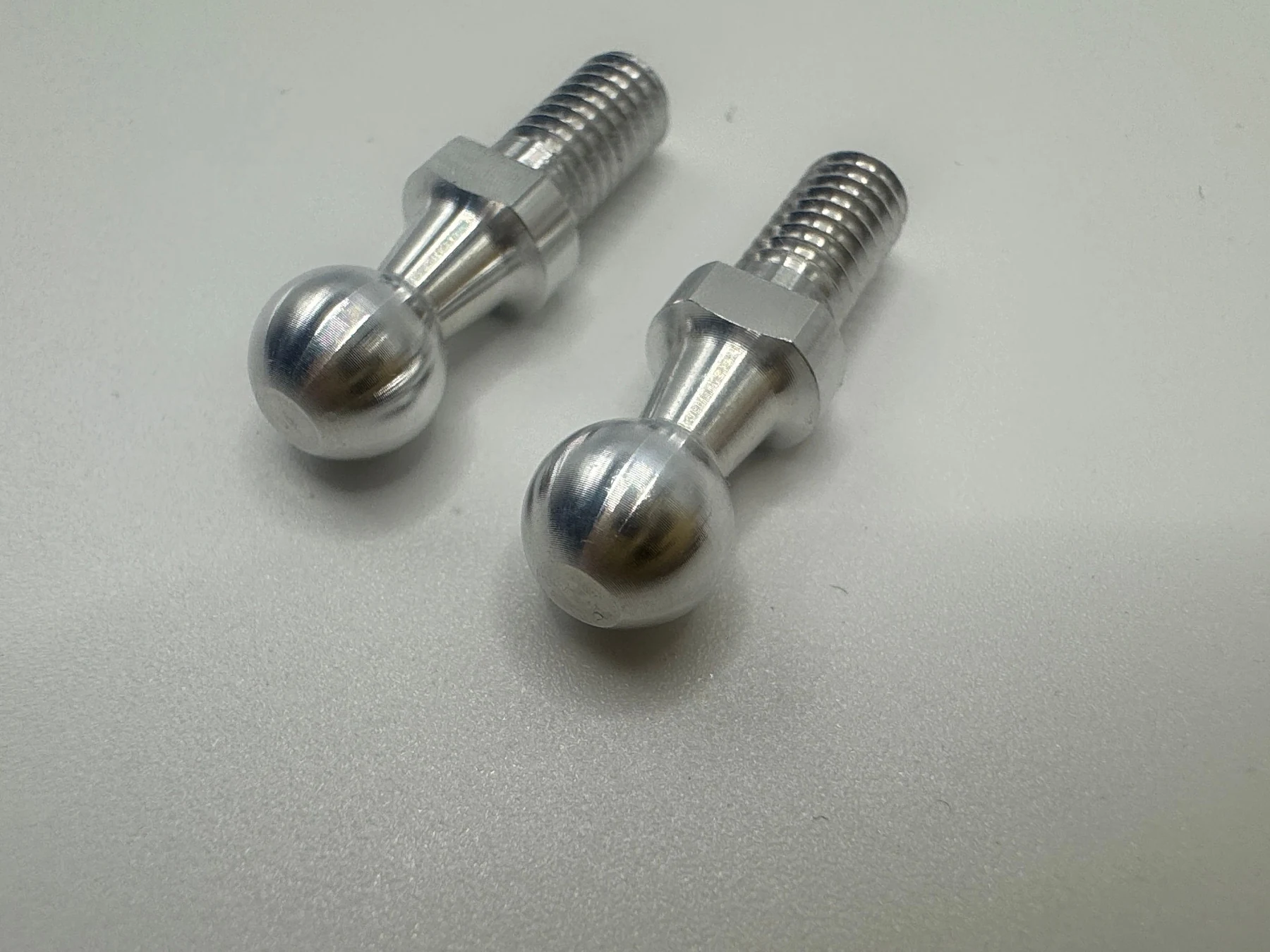 Two 6063 aluminum ball-head screws showing spherical heads, wrench flats and M4 external threads