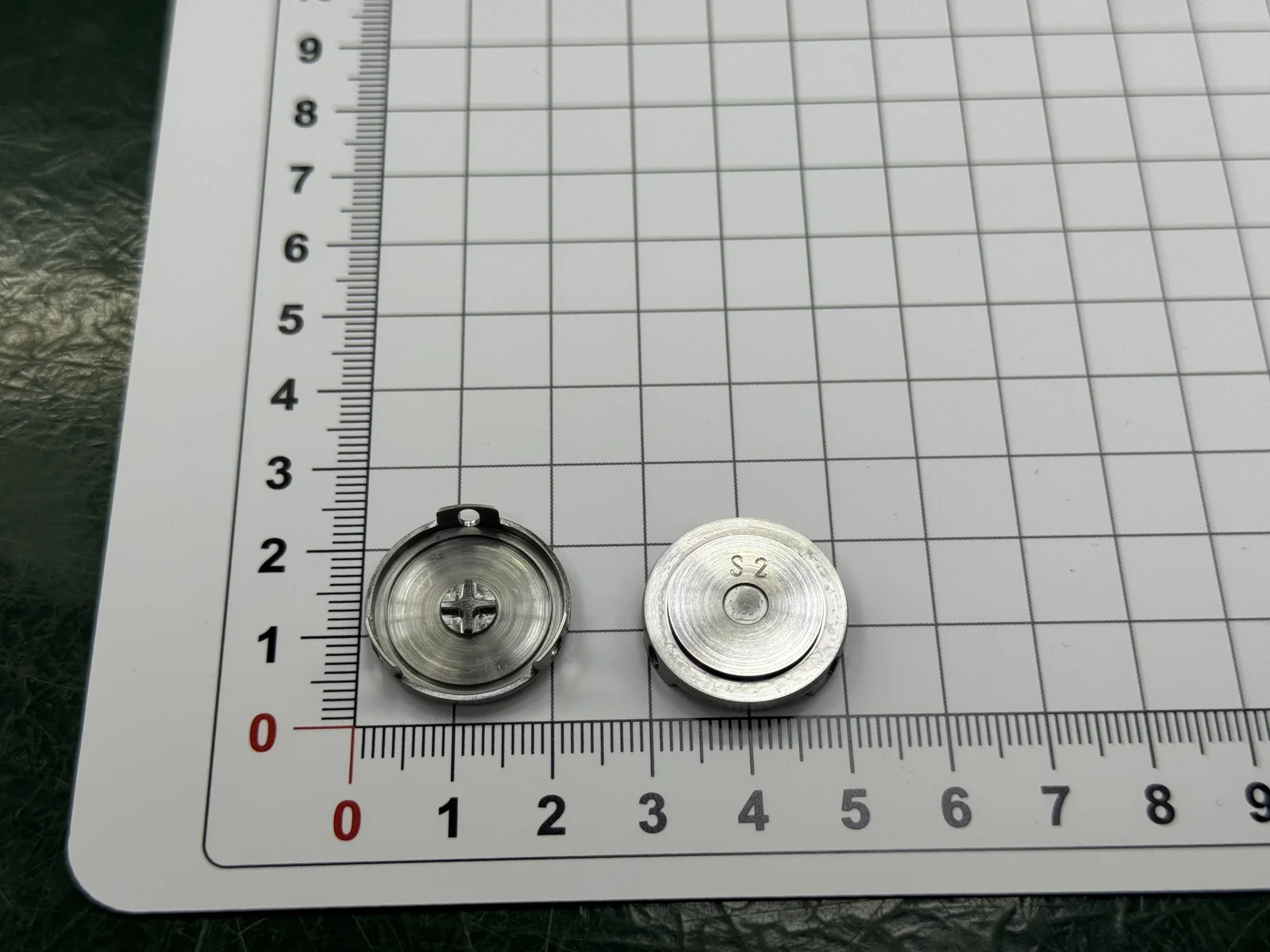 Two faces of the finished SUS420J2 component showing the S2 marking, narrow annular wall and internal cross geometry