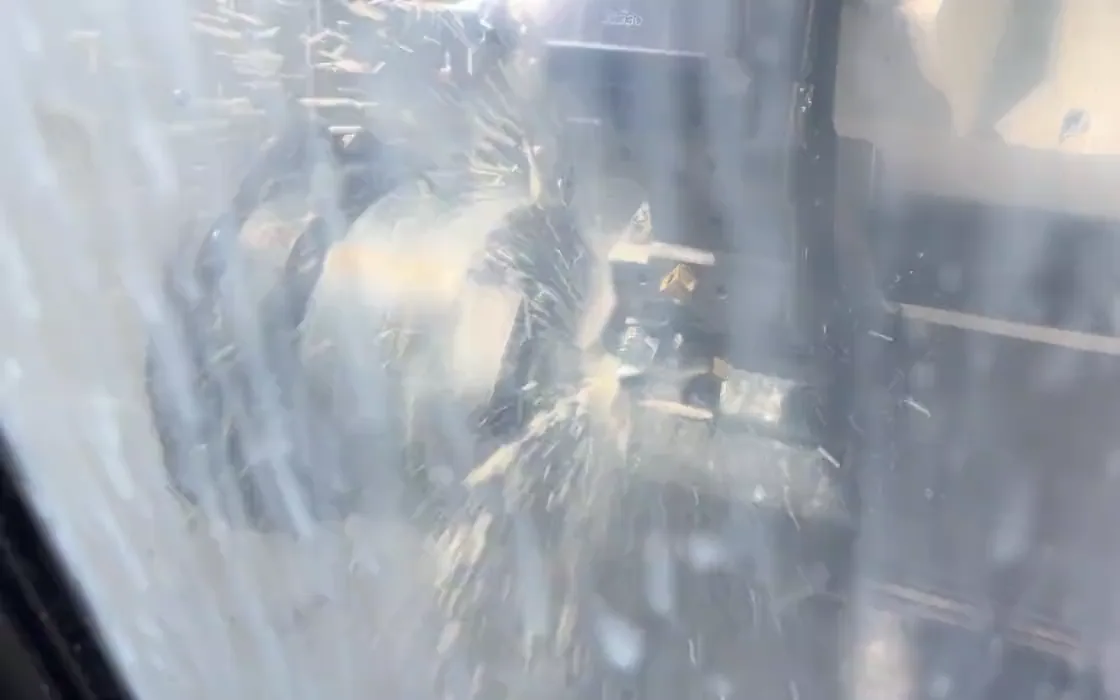 CNC lathe chuck, rotating workpiece and cutting tool under coolant