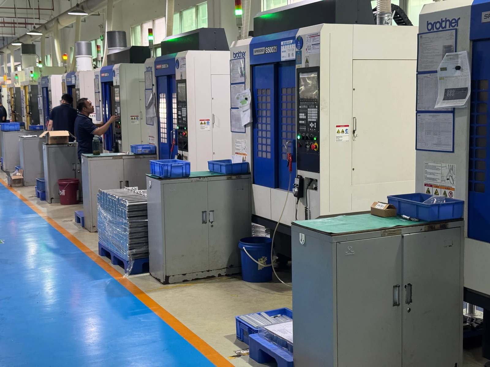 Operators beside Brother machining centers in OUJI's CNC milling workshop
