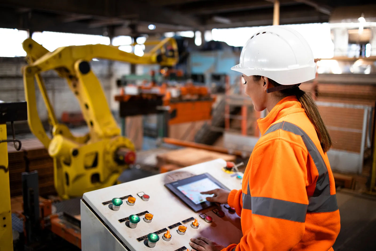 Industrial technician operating automated production equipment