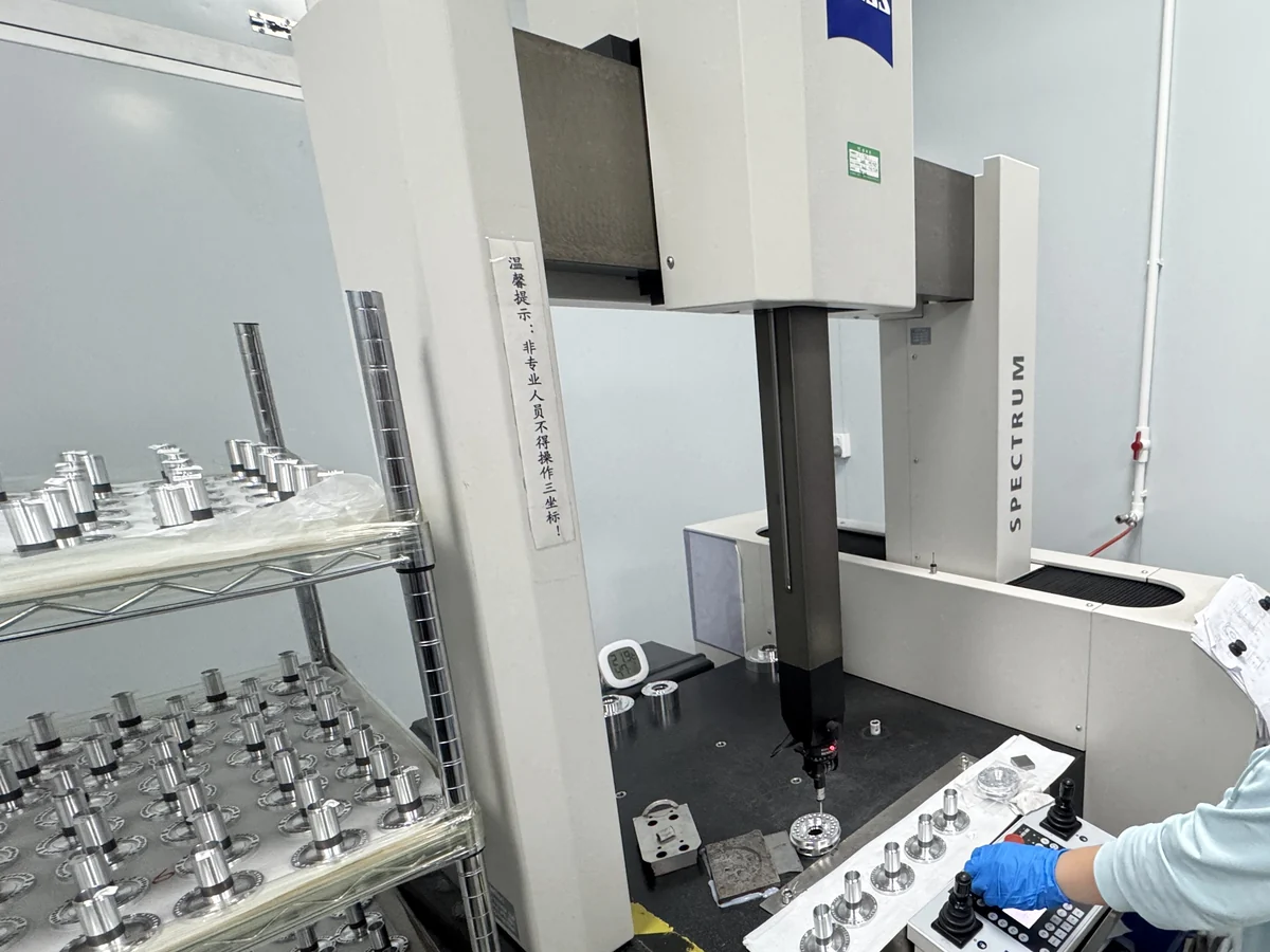 Robotics components staged for inspection beside a ZEISS coordinate measuring machine