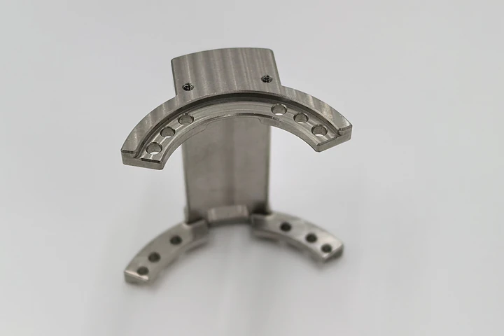 OUJI clamping component with curved contact faces and mounting holes