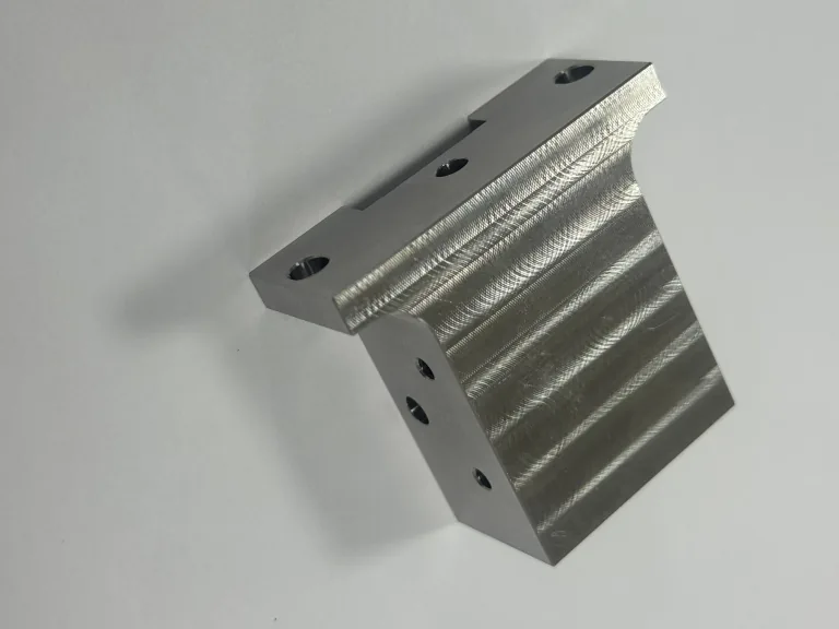 Finished 304 stainless steel component with bores and machined features on multiple faces