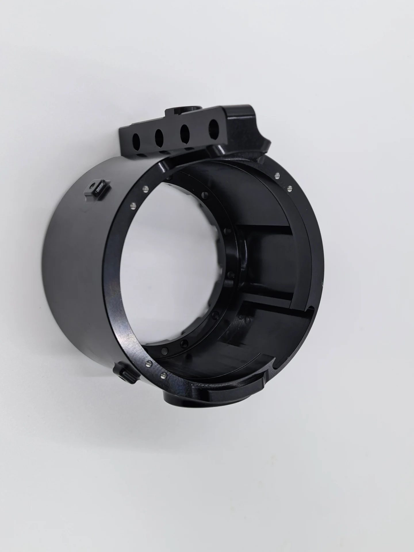 Black machined ring-shaped component with mounting holes and internal ribs