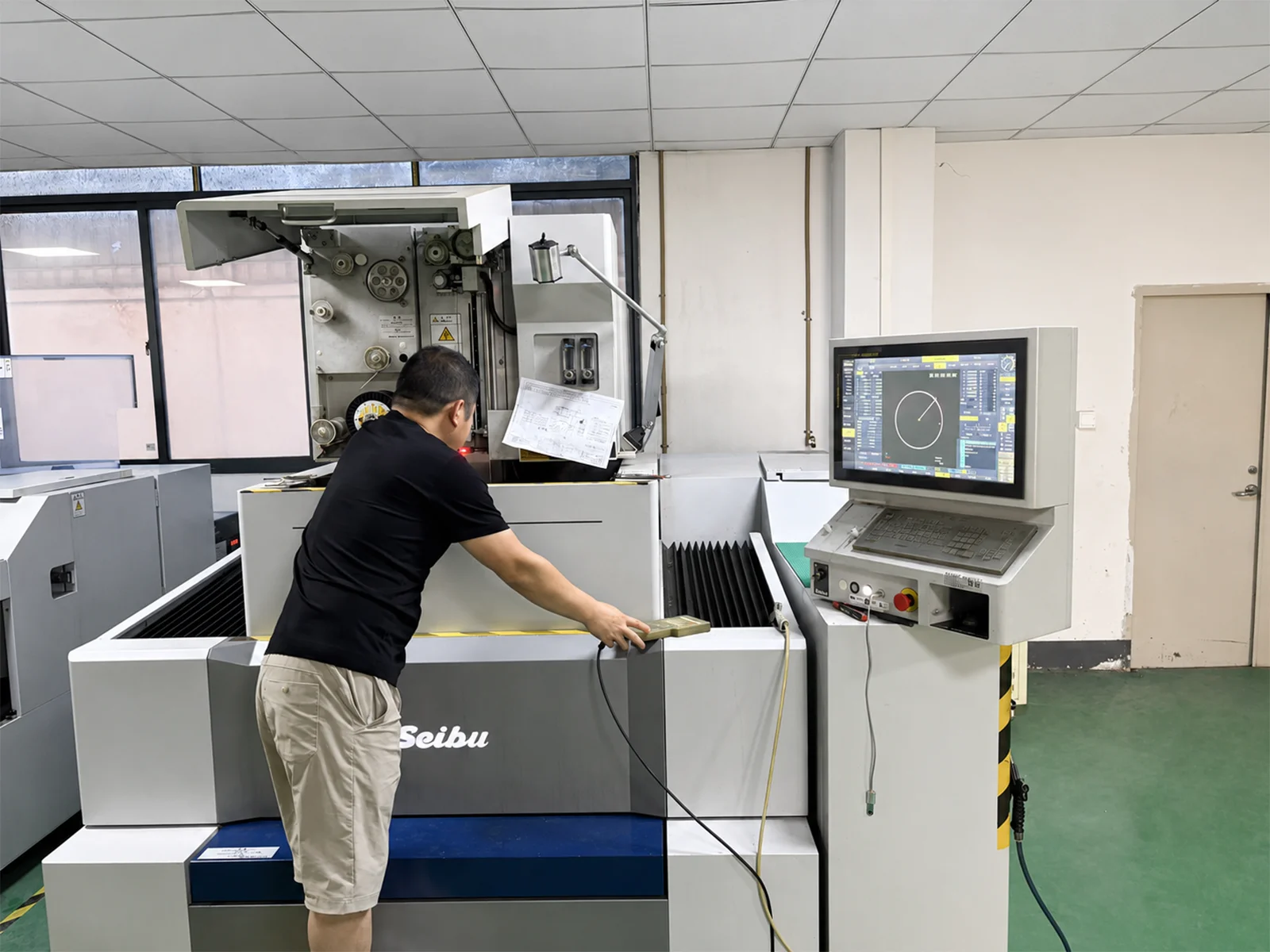 Wire EDM machine cutting a metal workpiece in dielectric fluid