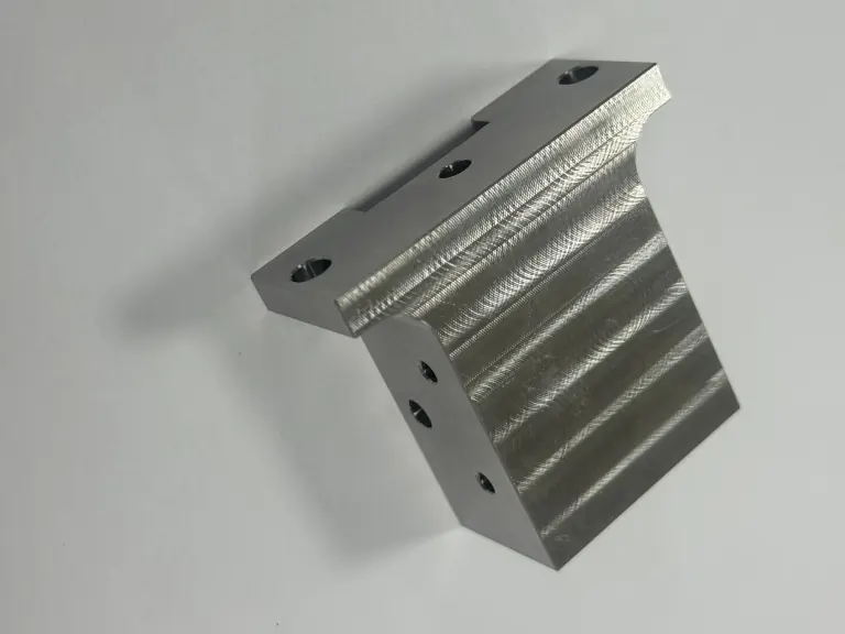 Actual OUJI 304 stainless steel part with precision bores and machined features on several faces